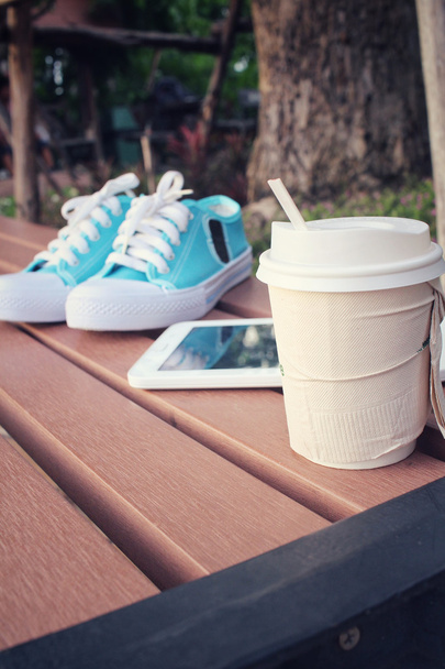 Πάνινα παπούτσια με δισκίο και καφέ χαρτί Κύπελλο - Φωτογραφία, εικόνα
