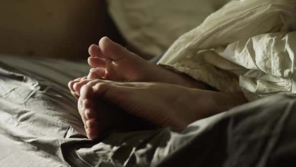 Nogi para w łóżku rano - Materiał filmowy, wideo