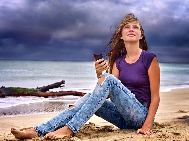 Chica en la arena cerca del mar llamada ayuda por teléfono
. - Foto, imagen