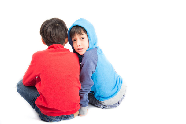 Little sibling boys sit together on white background - Photo, Image