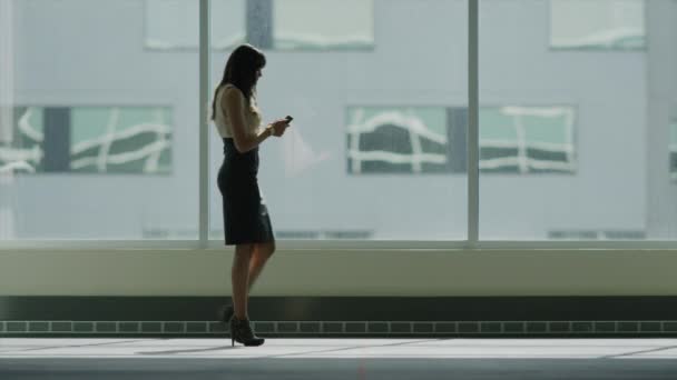Mujer de negocios caminando y usando el teléfono celular
 - Metraje, vídeo
