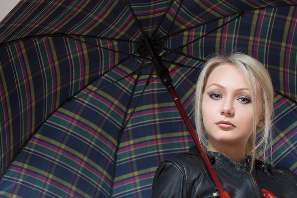 blonde girl, standing under an umbrella checkered - Photo, image