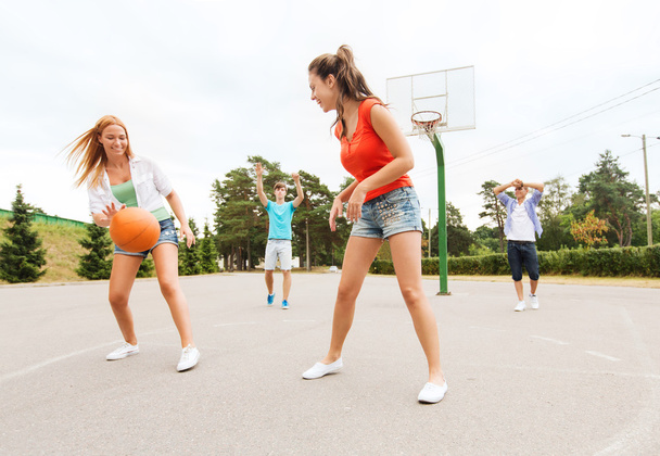 group of happy teenagers playing basketball - 写真・画像