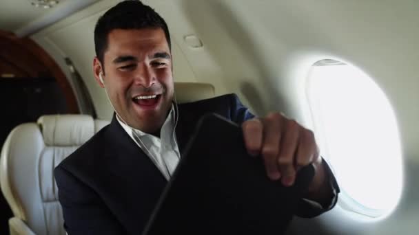 Businessman playing with digital tablet in airplane - Felvétel, videó