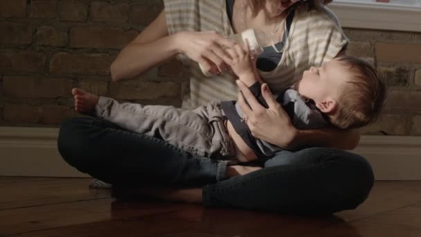 Young mother feeding baby boy - Materiał filmowy, wideo