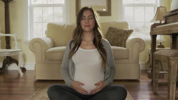 Беременная мать медитирует в гостиной
  - Кадры, видео