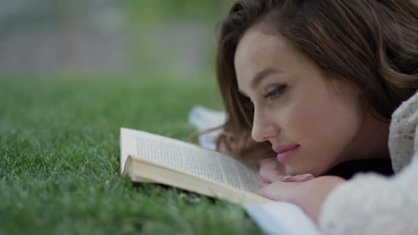 woman reading book in grass - Filmati, video
