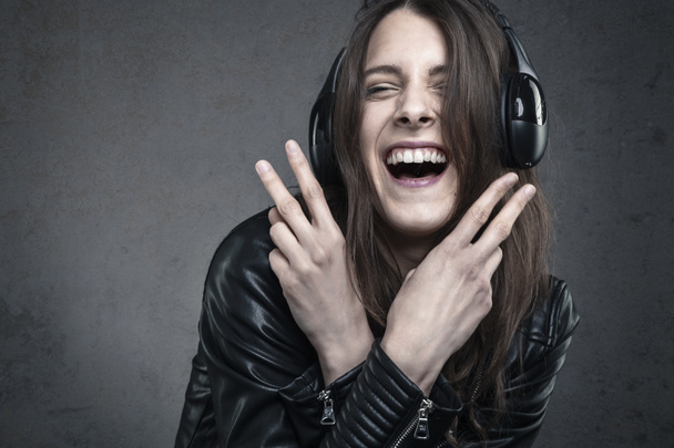Baş telefonlarıyla karşı müzik dinlemek genç kadın gülüyor - Fotoğraf, Görsel