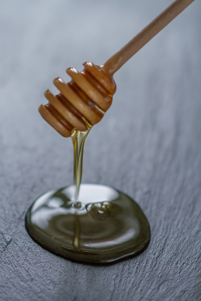 Honey and wooden honey dipper - 写真・画像