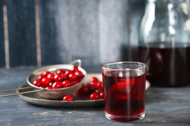 Glass with cherry juice on table, on wooden background - Foto, imagen