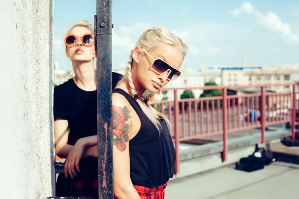 two pretty hipster sisters against urban white wall - Foto, imagen