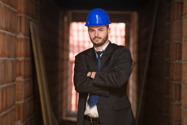 Portret van jonge bouw manager met gekruiste armen - Foto, afbeelding