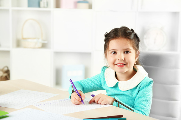 Linda niña haciendo su tarea
 - Foto, Imagen