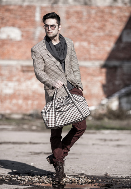 модный человек, держащий сумку p
 - Фото, изображение