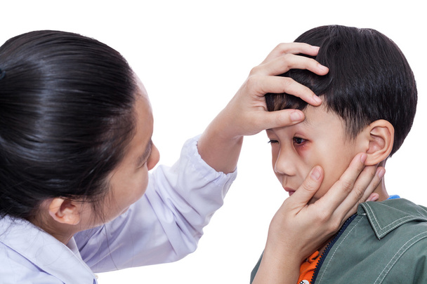 Un chico con un ojo herido. Médico examinando y primeros auxilios un paciente
 - Foto, Imagen