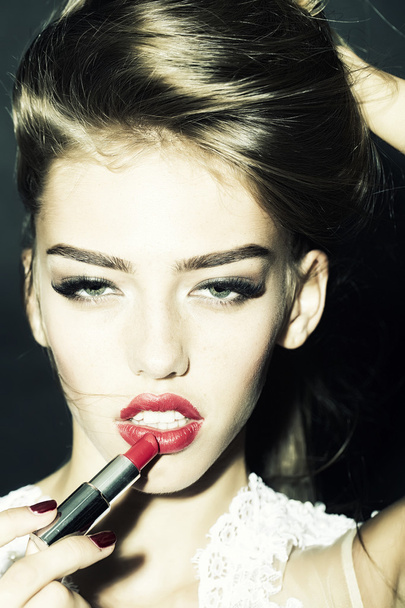 Girl putting on lipstick - Fotoğraf, Görsel