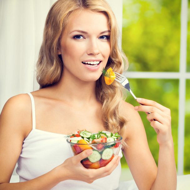 Женщина ест салат, в помещении
 - Фото, изображение