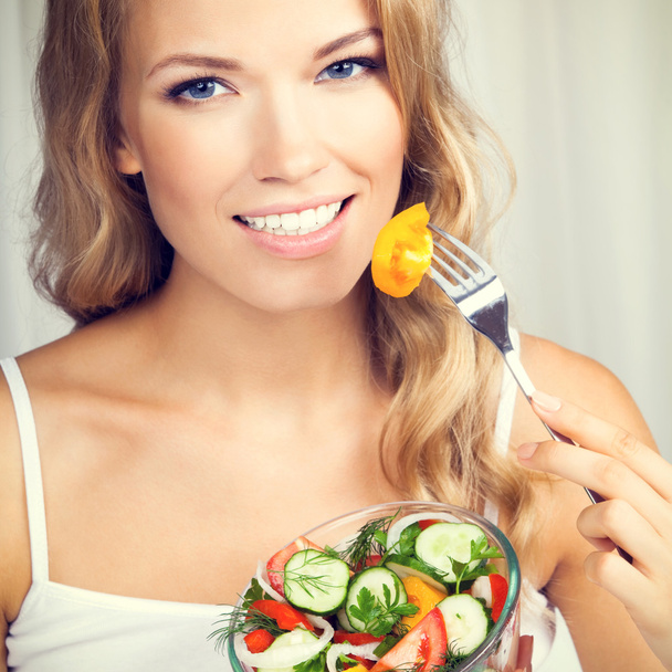 Frau isst Salat, drinnen - Foto, Bild