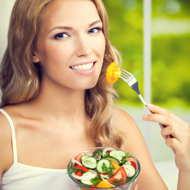Woman eating salad, indoors - Foto, Bild