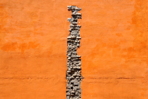 Grieta de ladrillos en pared naranja
 - Foto, imagen