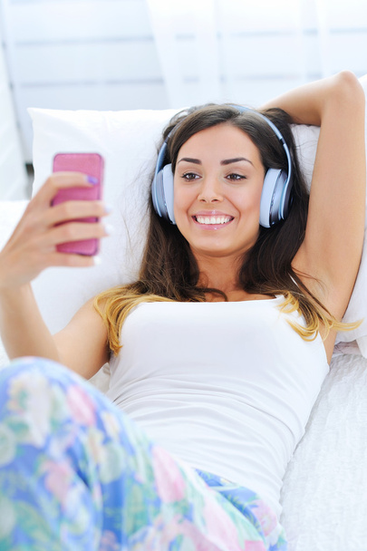 Beautiful young woman in headphones listening to music - Foto, Bild