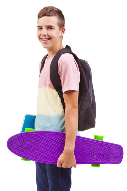 school boy holding a skateboard and notebooks - Foto, Bild