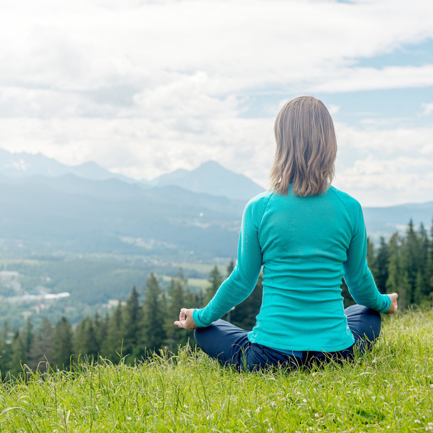 Nainen meditoi vuorilla
 - Valokuva, kuva