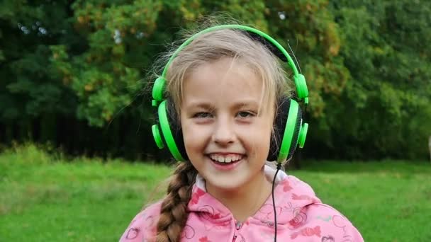 dziewczyna słuchania muzyki w słuchawkach - Materiał filmowy, wideo