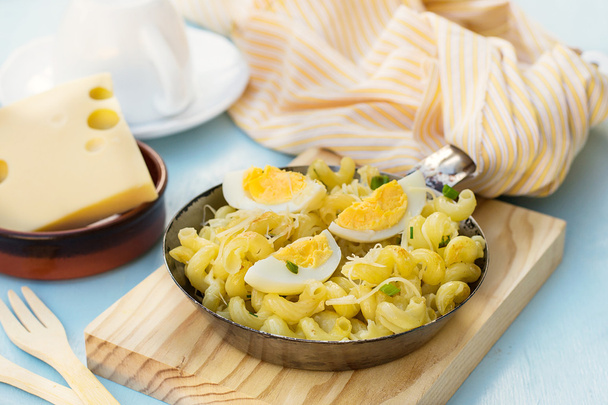 Жареная паста с вареными яйцами, сыром и луком
 - Фото, изображение