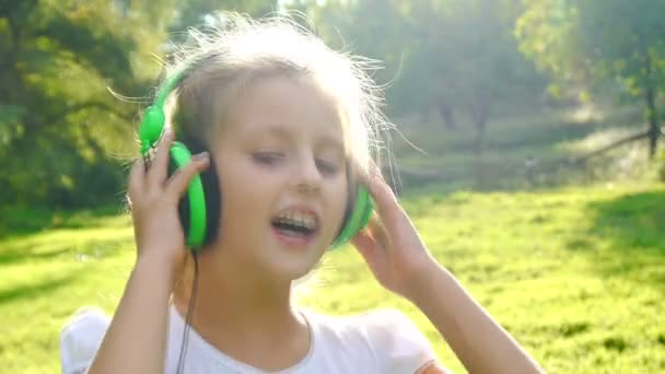 Dívka poslouchá hudbu za slunečného dne - Záběry, video