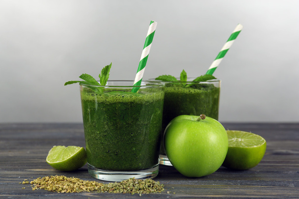 Green healthy juice with fruits and mint on gray background - Photo, image