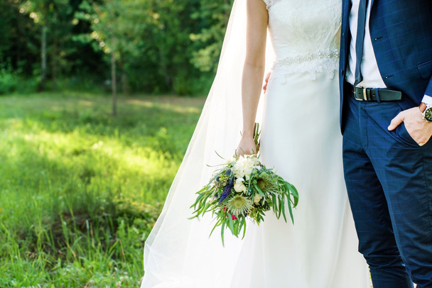 Groom and bride holding flowers - Foto, afbeelding