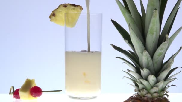 Pouring pina colada with pineapples in the foreground - Materiał filmowy, wideo