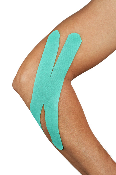 young man with an elastic therapeutic tape in his arm - Photo, Image