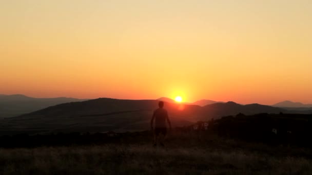 Jonge Man aanbidding op een prachtige zonsondergang - Video