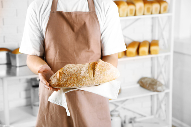Baker checking freshly baked bread - Foto, imagen