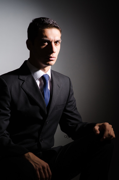 Young businessman in dark studio - Photo, Image
