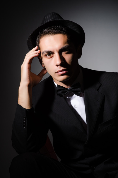 Jonge zakenman in donkere studio - Foto, afbeelding