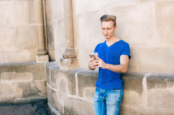 Junger Mann mit Handy auf der Straße - Foto, Bild