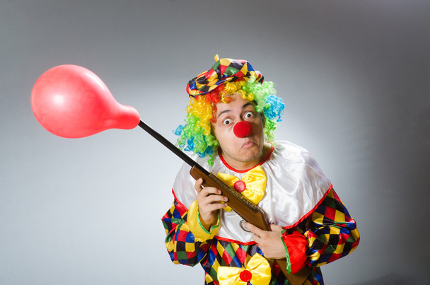 Клоун з повітряною кулею і рушницею в смішній концепції
 - Фото, зображення