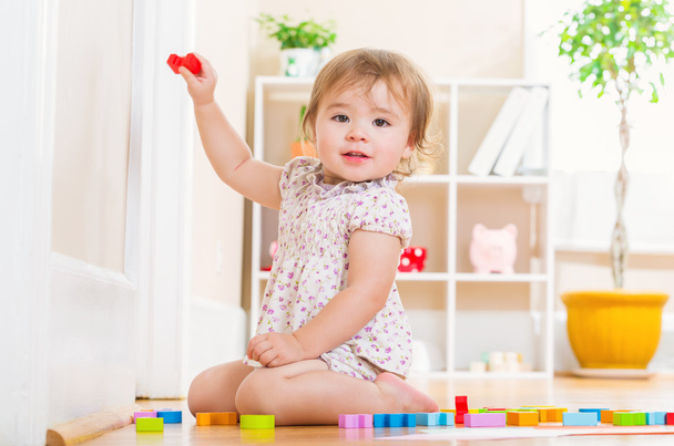 Toddler girl playing with her toy blocks - Фото, изображение