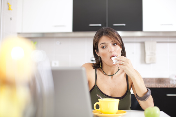Mujer moderna leyendo e-mails en su desayuno
 - Foto, Imagen