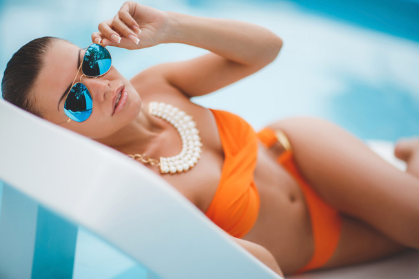 Happy woman on vacation near the blue pool - Zdjęcie, obraz