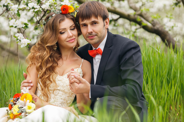 Portrait newlyweds in the lush spring garden - Fotoğraf, Görsel