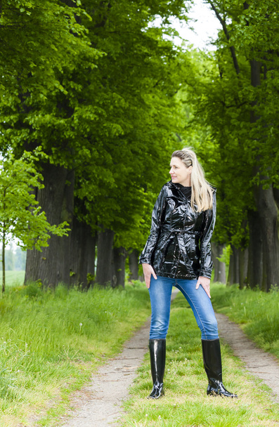 Frau trägt Gummistiefel in Frühlingsgasse - Foto, Bild