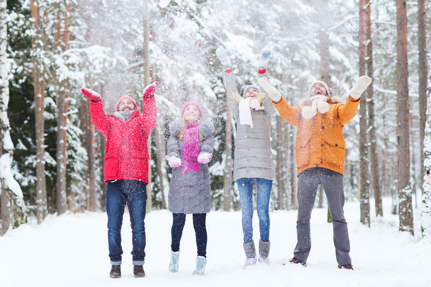 group of happy friends playin with snow in forest - Valokuva, kuva
