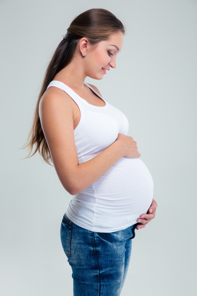 Pregnant woman caressing her belly - Фото, зображення