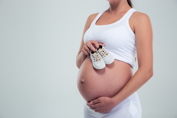 Pregnant woman holding a baby booties - Φωτογραφία, εικόνα
