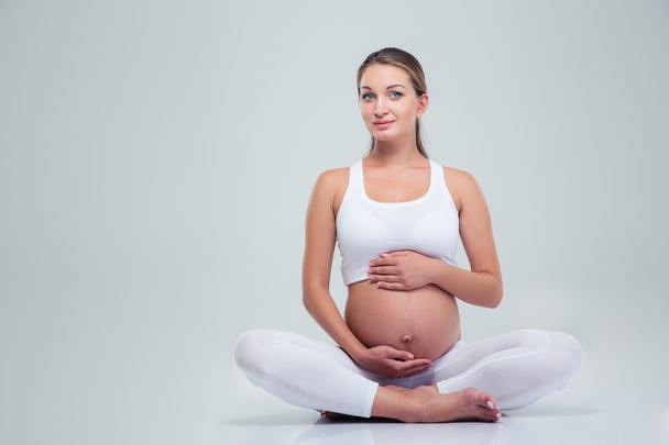 Pregnant woman sitting on the floor - Foto, Bild