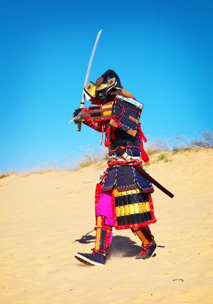 Ο άνθρωπος στο κοστούμι Σαμουράι με σπαθί, τρέξιμο στην άμμο. - Φωτογραφία, εικόνα